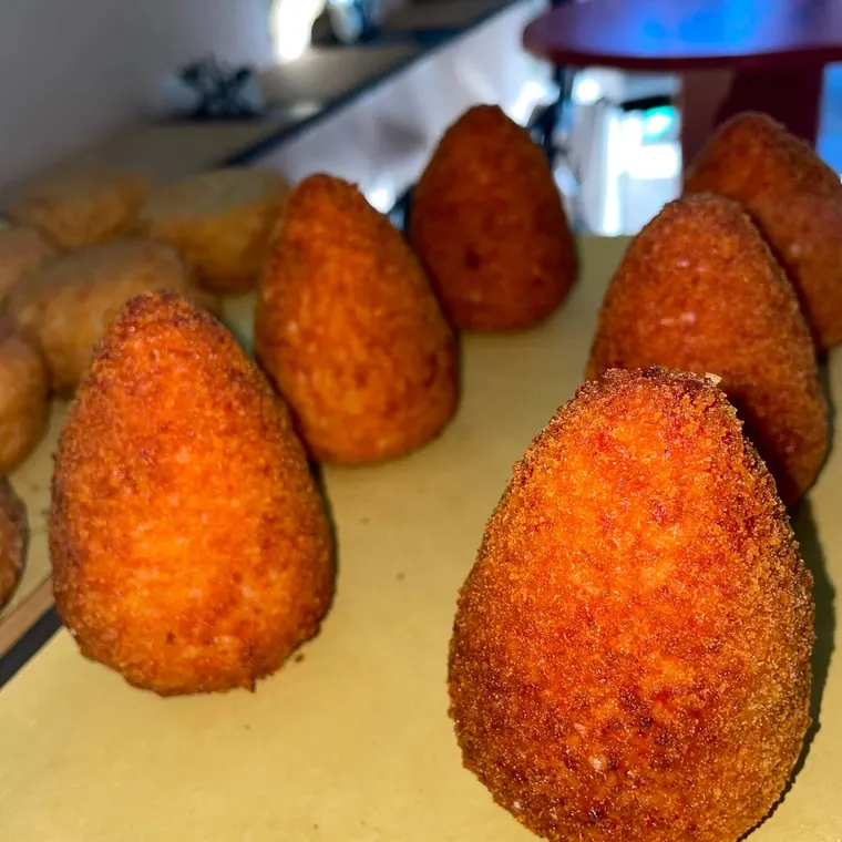 Arancini dorati sul vassoio, in vetrina